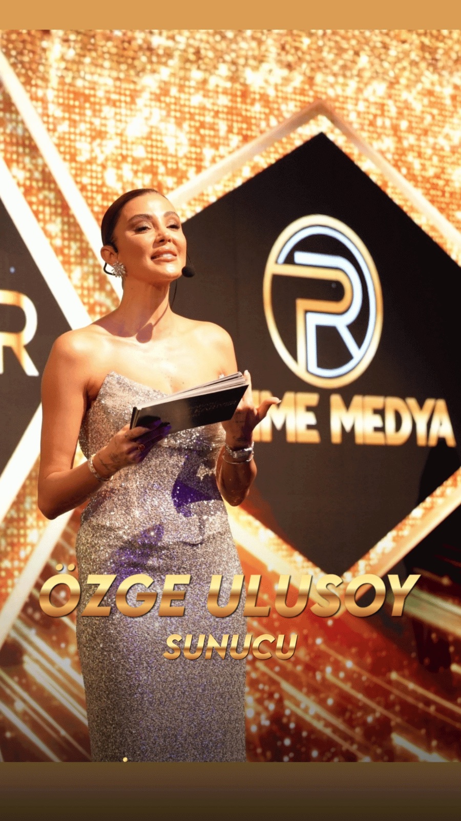 Özge Ulusoy altın sahnede ödül takdimi yaparken